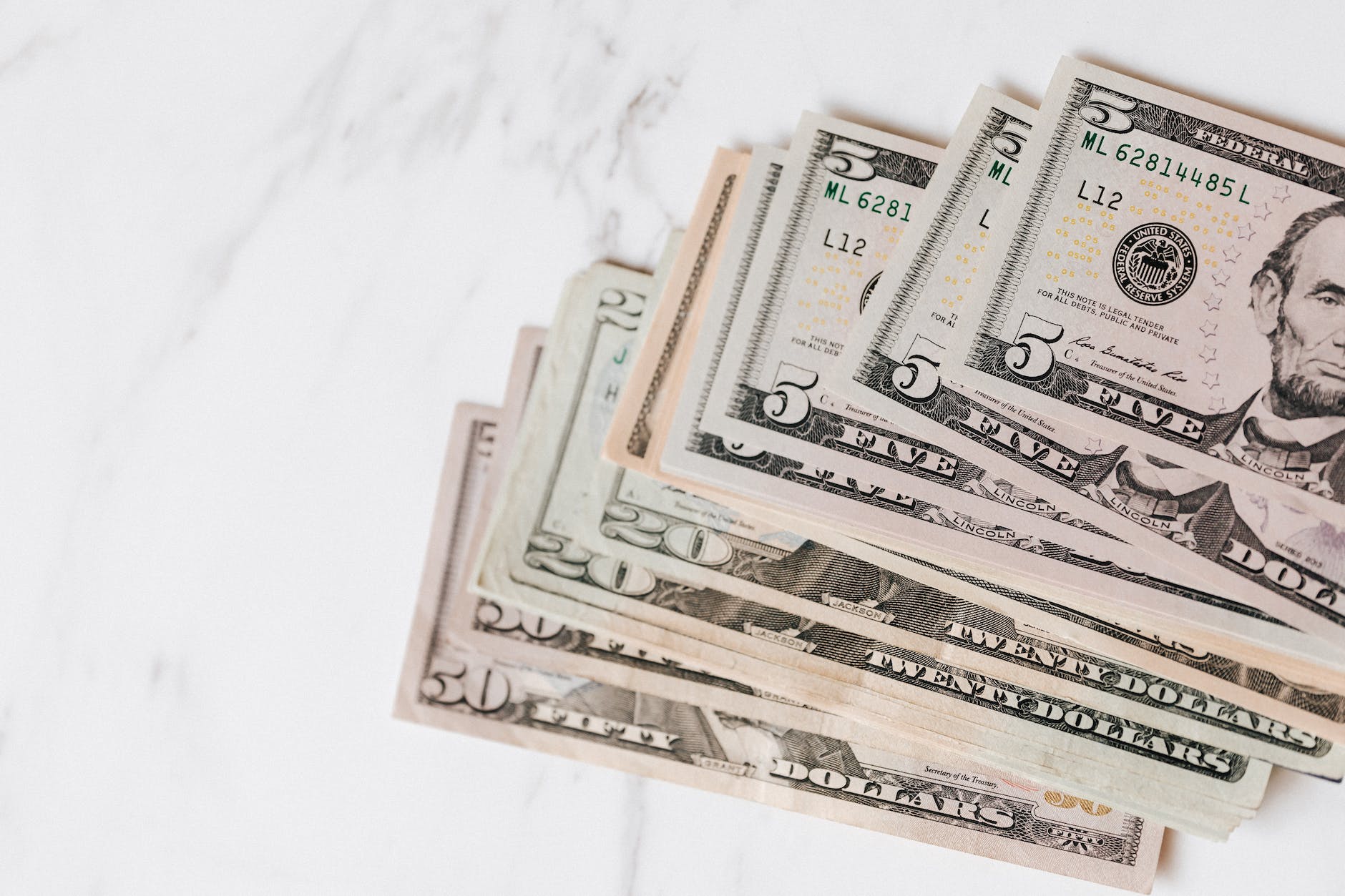 different dollar bills on marble surface