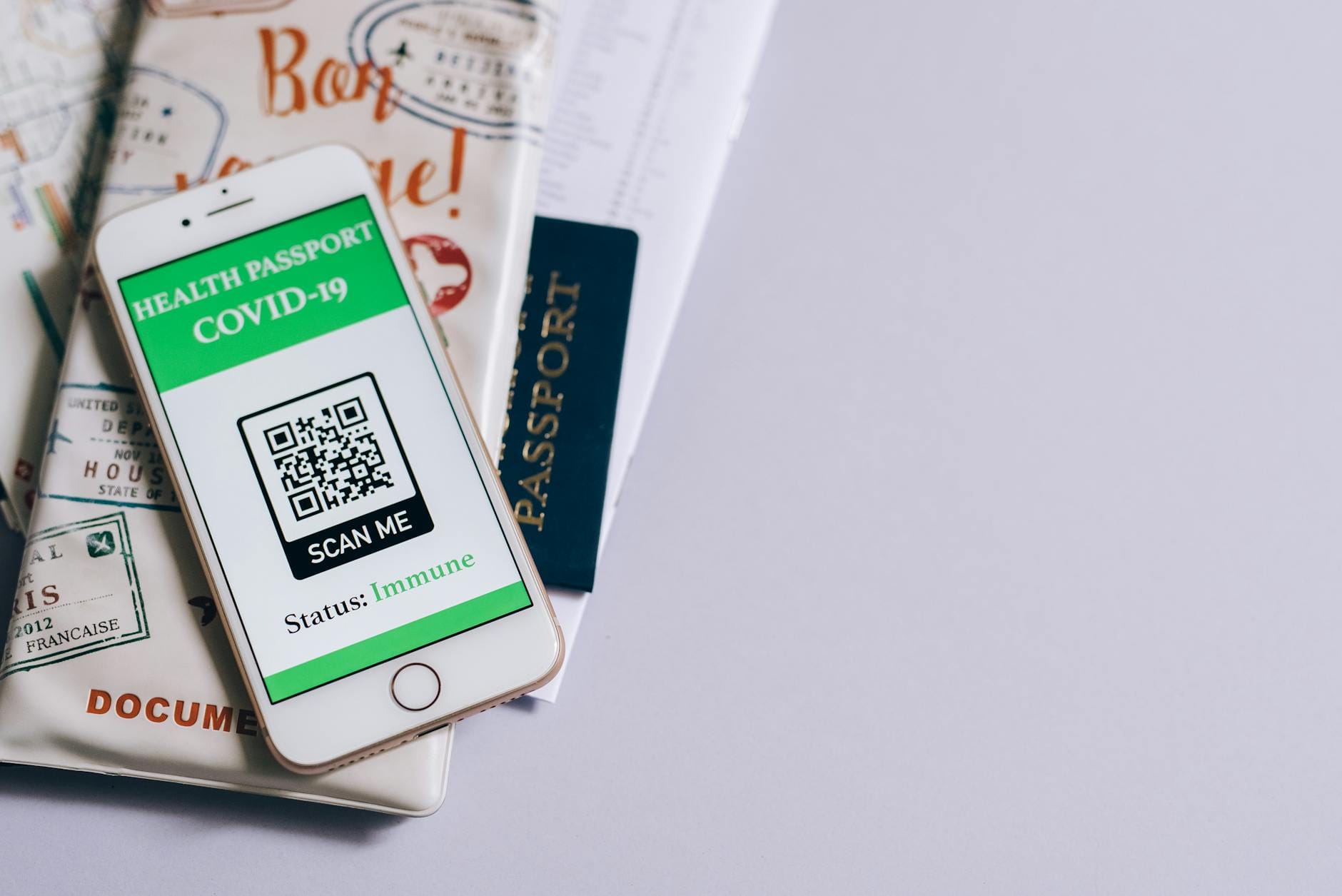 smart phone with a health passport app and travel documents lying on a table