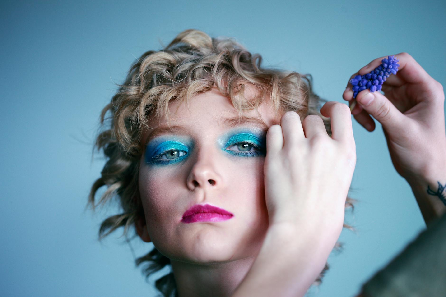 portrait of woman wearing teal eyelashes