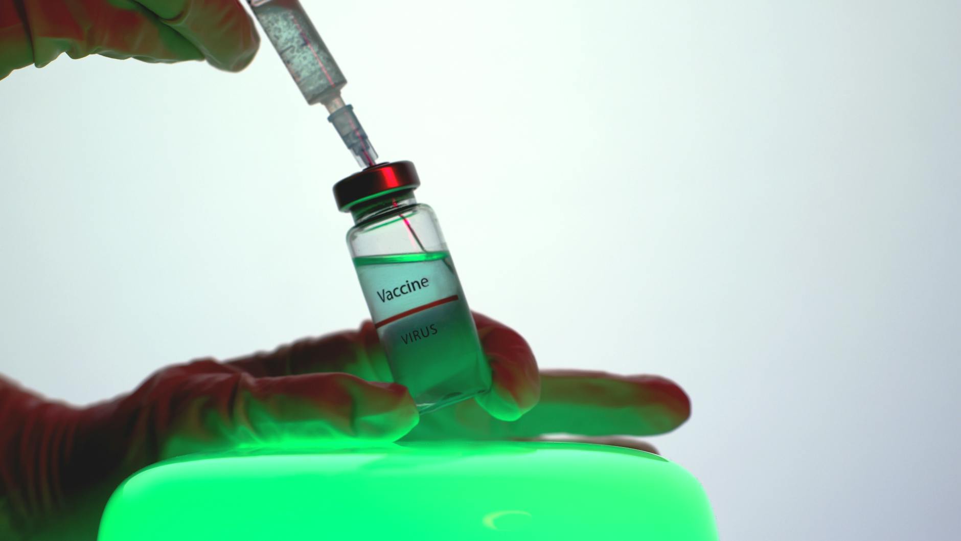 person aspirating the vaccine from the vial
